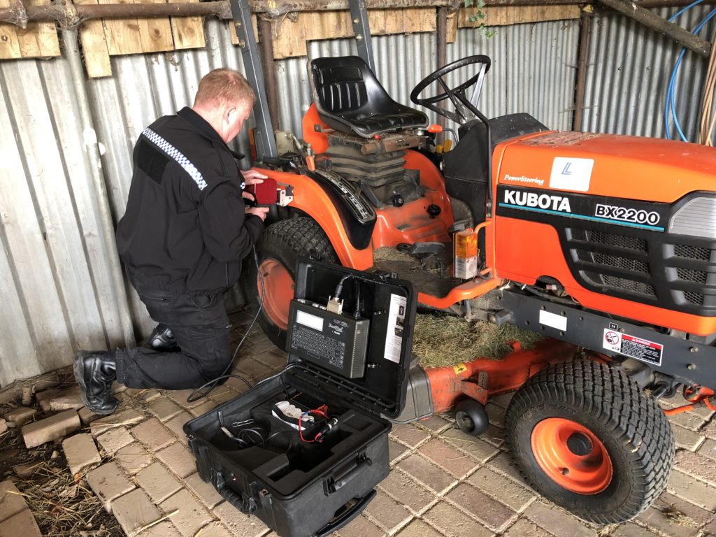 policeman fitting electronics to vehicle